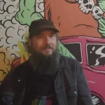"Musician Tim Holehouse portrait in front of a colorful mural for an interview about folk punk music, touring and songwriting.