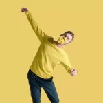 Dance theatre production image showing a man in a yellow sweater with flowers covering his face, representing childhood trauma, resilience, healing, and emotional recovery.